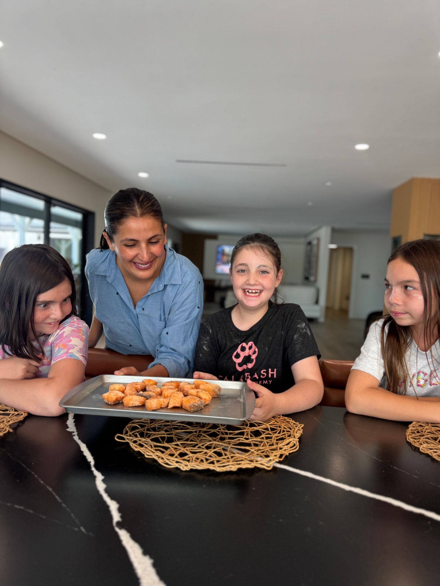A teacher and young cooks with a tray of warm treats